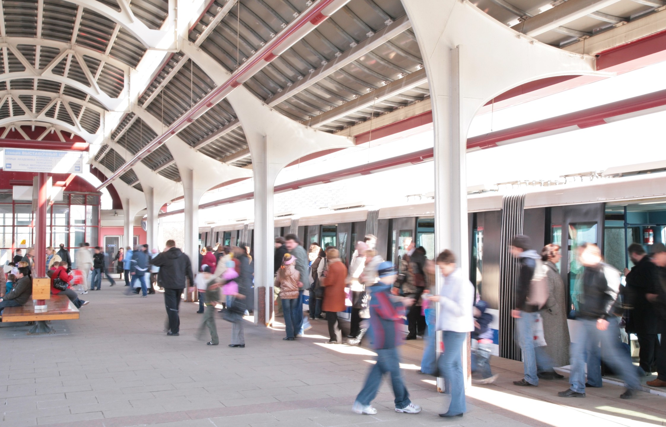 A busy train platform with passengers exiting a train.
