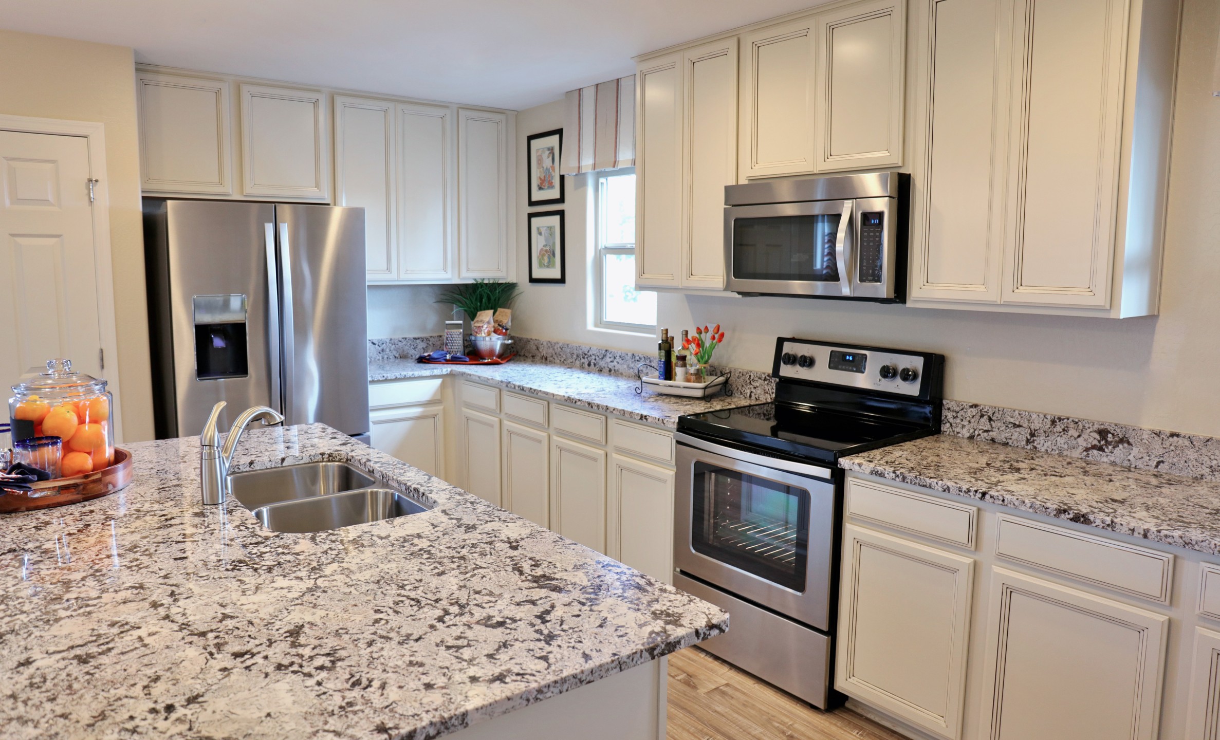 A modern kitchen with stainless steel appliances and marble countertops.