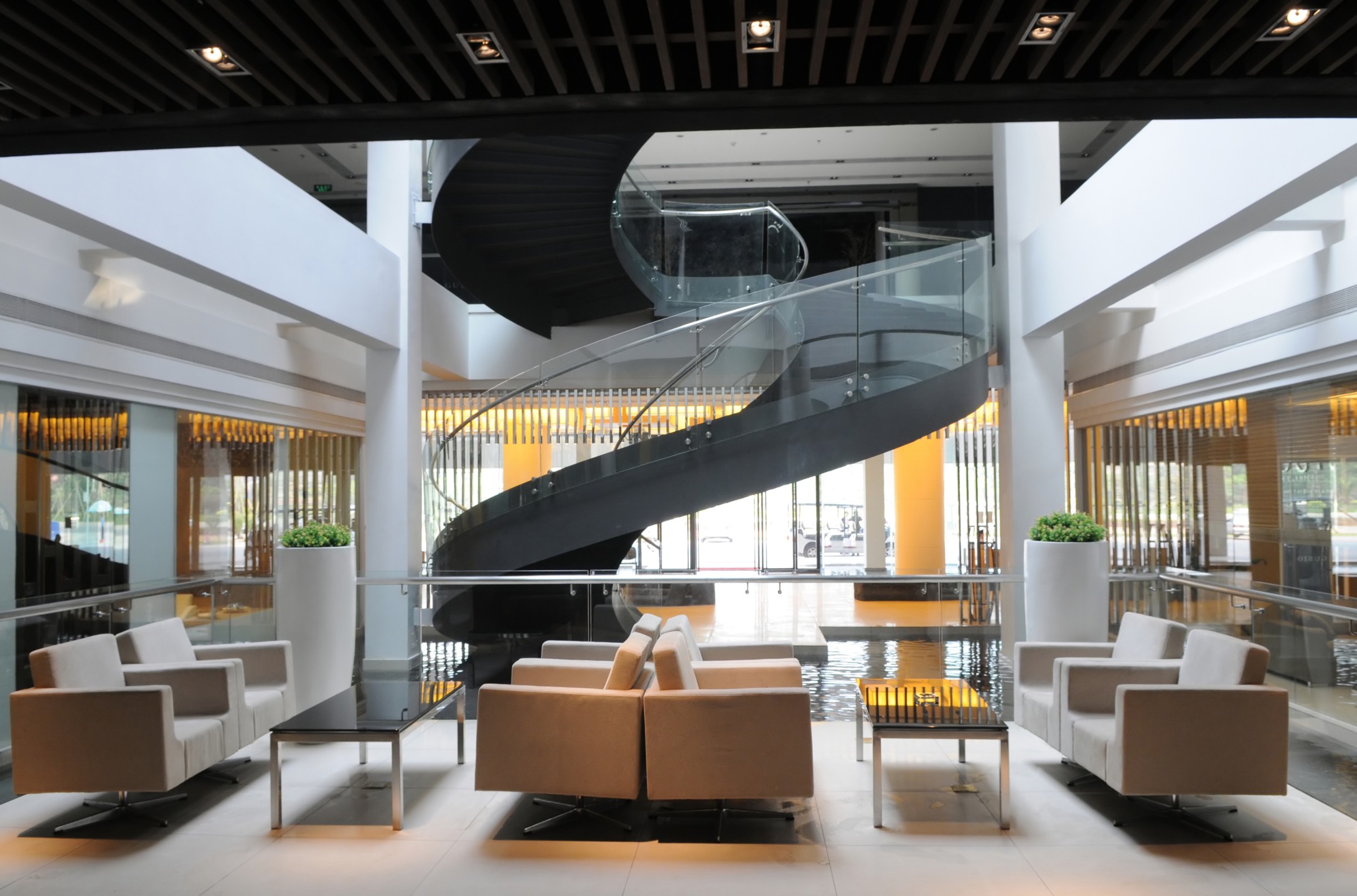 A modern lobby with seating and a spiral staircase.