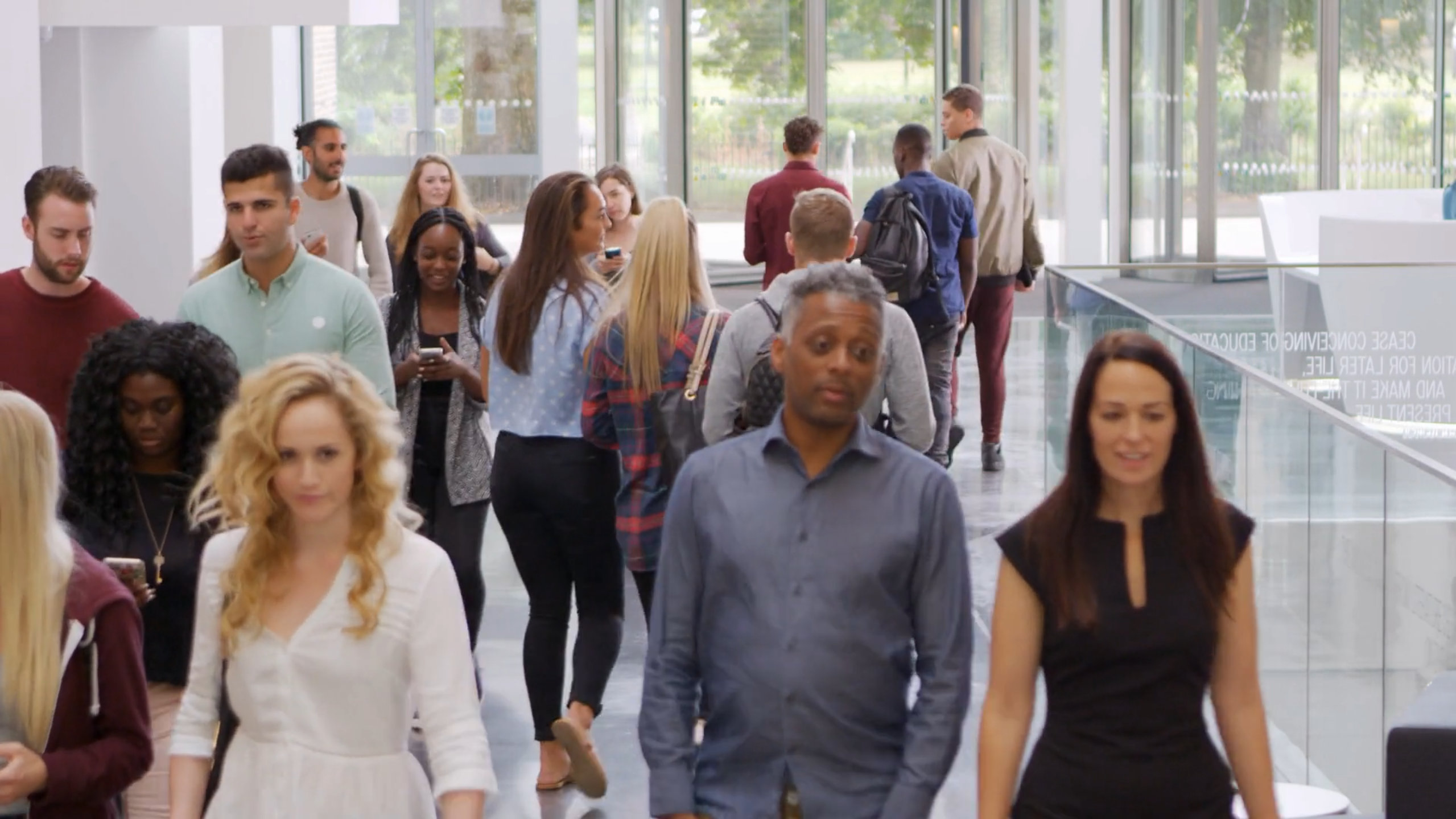A group of people walk through a modern lobby.