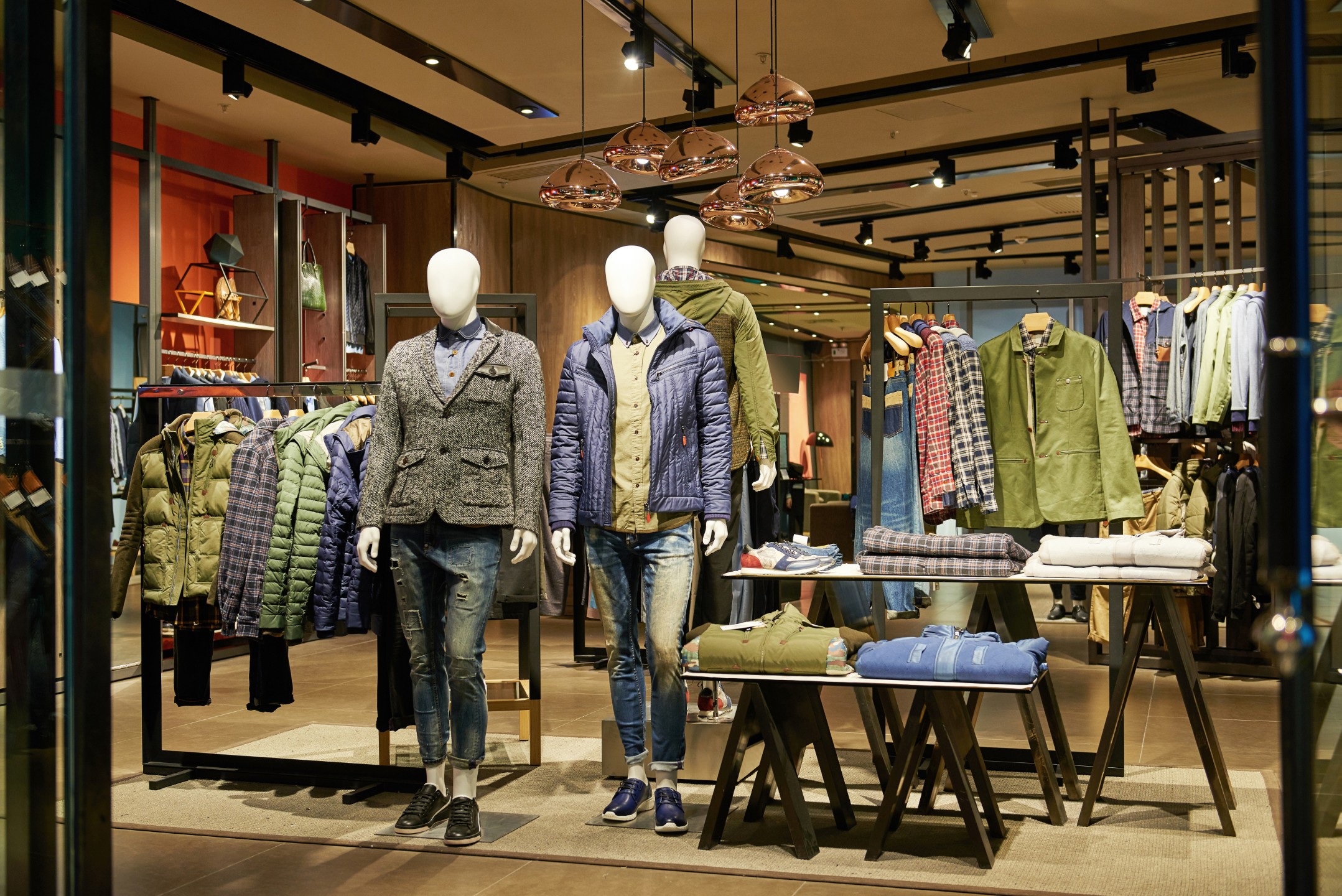 A storefront window of an outdoor clothing retailer at night.